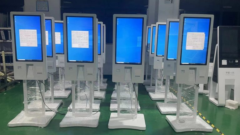 Touchscreen self-service kiosks lined up in the factory