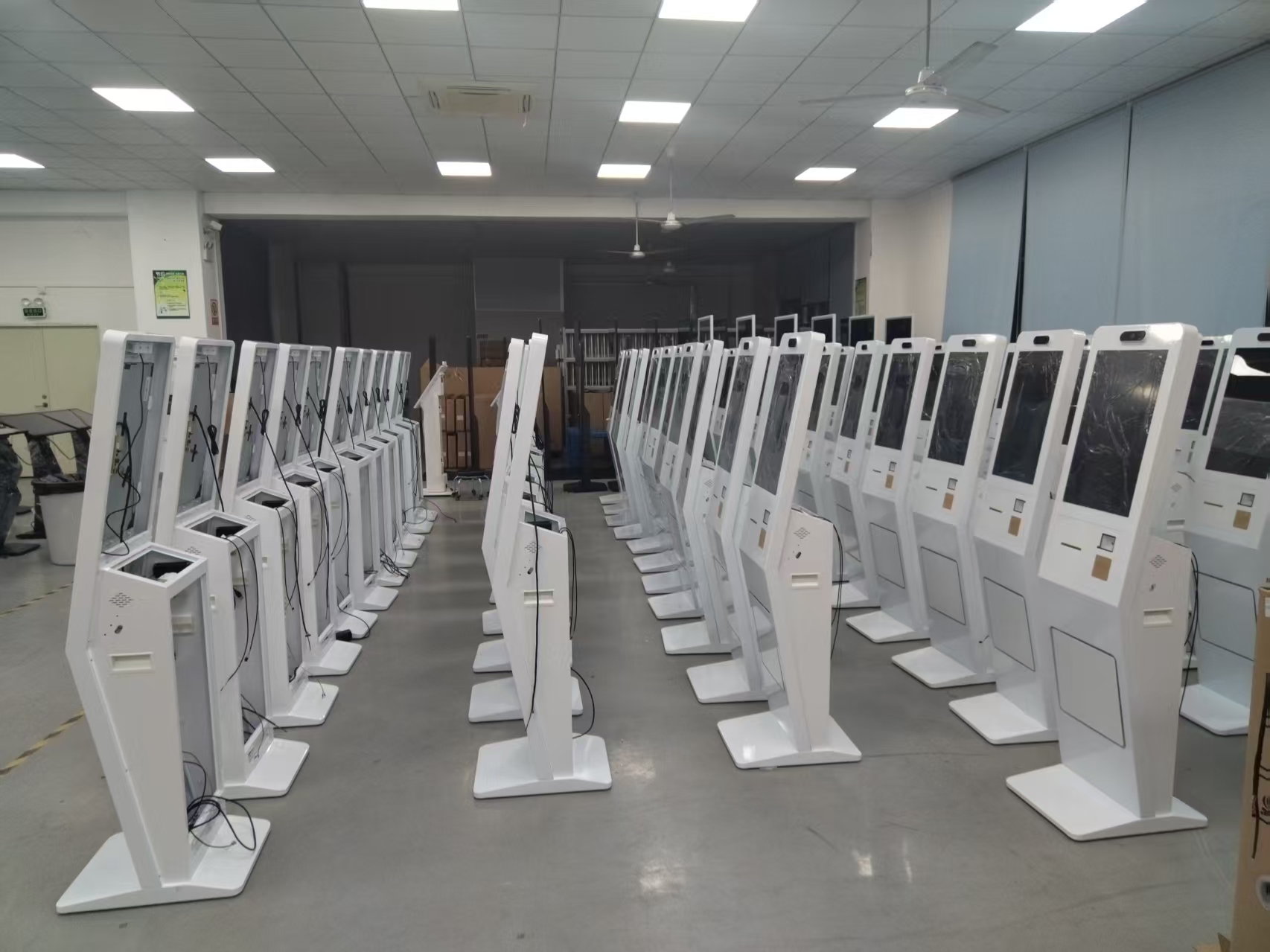Front and rear views of self-service kiosks arranged for assembly
