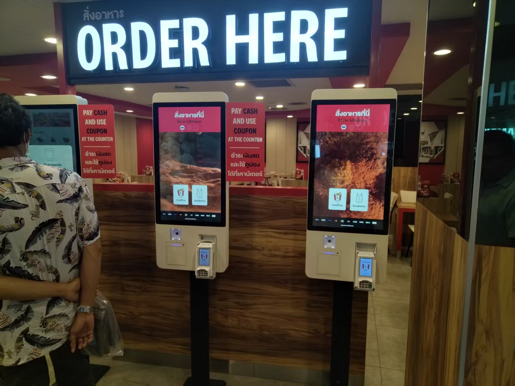 Two self-ordering POS terminals with card readers at a restaurant counter
