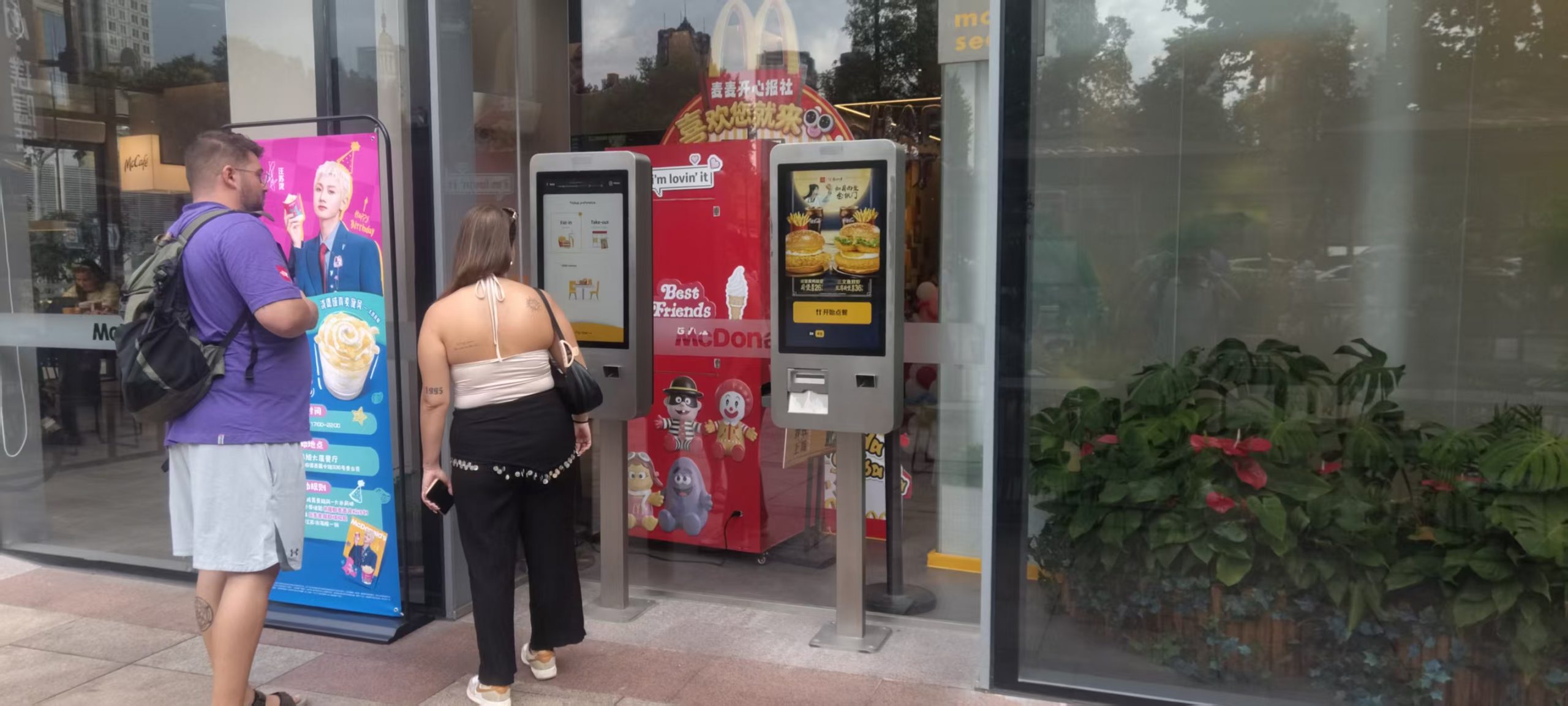 Customer choosing items on a self-ordering kiosk outside a restaurant